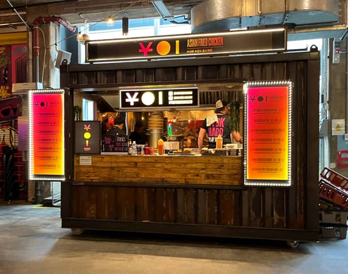 a storage container converted to a food stall with menu baords
